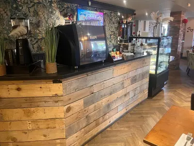 a bar with a tv on top of a wooden counter at King Alfred Hotel in Barrow in Furness