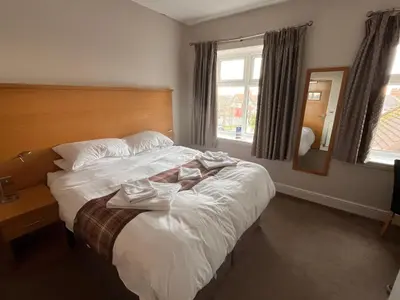 a hotel room with a bed with towels on it at King Alfred Hotel in Barrow in Furness