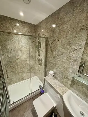 a bathroom with a shower and a toilet and a sink at King Alfred Hotel in Barrow in Furness