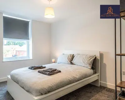 a white bedroom with a bed with towels on it at Swan House Apartment 9 - 2 Bed Apartment - Sleeps 6 - Free Parking - Liverpool - close to city centre - By ALL ELITE STAYS in Liverpool