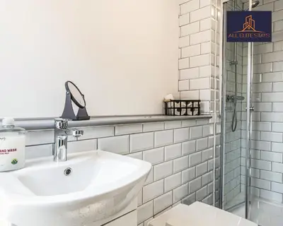 a white bathroom with a sink and a shower at Swan House Apartment 9 - 2 Bed Apartment - Sleeps 6 - Free Parking - Liverpool - close to city centre - By ALL ELITE STAYS in Liverpool