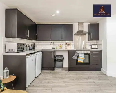 a kitchen with black cabinets and white appliances at Swan House Apartment 9 - 2 Bed Apartment - Sleeps 6 - Free Parking - Liverpool - close to city centre - By ALL ELITE STAYS in Liverpool