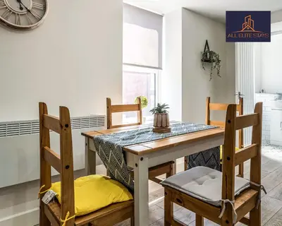 a dining room with a wooden table and chairs at Swan House Apartment 9 - 2 Bed Apartment - Sleeps 6 - Free Parking - Liverpool - close to city centre - By ALL ELITE STAYS in Liverpool