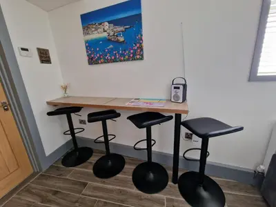 a table with four stools in a room at Seabreeze The Annexe in Blackpool