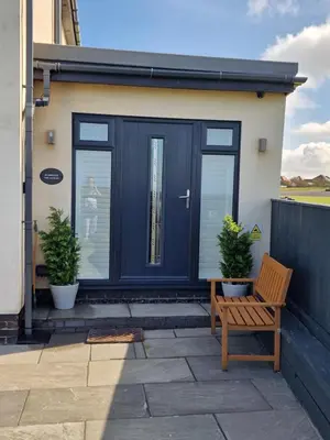 a house with a blue door and a wooden bench at Seabreeze The Annexe in Blackpool