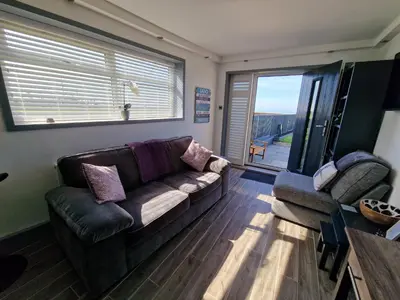 a living room with a couch and a large window at Seabreeze The Annexe in Blackpool