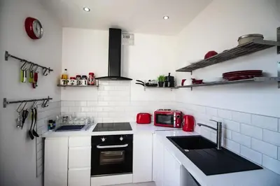 a white kitchen with a sink and a microwave at Blackpool Townhouse in Blackpool