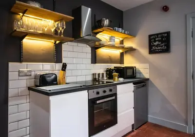 a kitchen with a stove and a microwave at Blackpool Townhouse in Blackpool