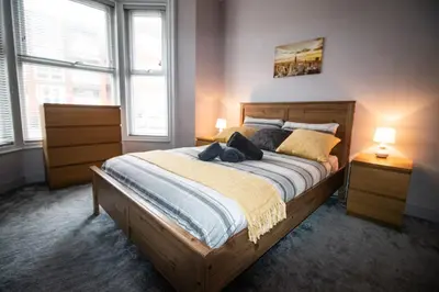 a bedroom with a large wooden bed with two lamps at Blackpool Townhouse in Blackpool