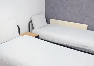 two beds in a small room with white sheets at Matchday Mile House Walk to Anfield sleeps 8 in Liverpool