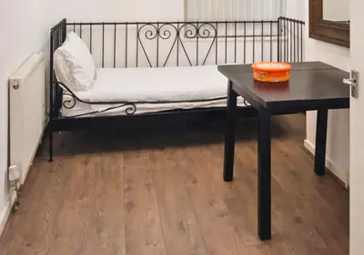 a bench with a table in a room with a wooden floor at Matchday Mile House Walk to Anfield sleeps 8 in Liverpool
