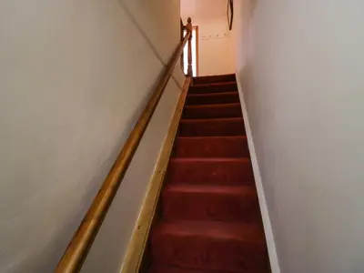 a staircase with red carpeting and a stair case at Time and Tide in Carnforth