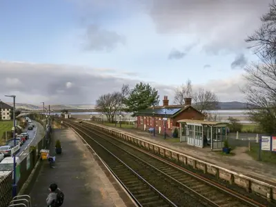 a train station with a train track next to a building at Time and Tide in Carnforth