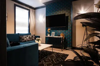 a living room with a blue couch and a tv at Entire Modern House Liverpool, 6 Bedrooms in Liverpool