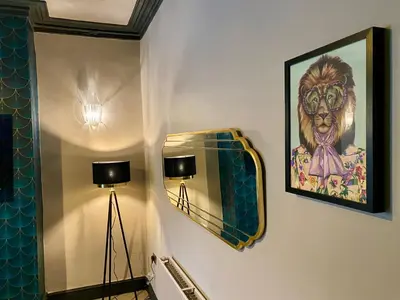 a bathroom with a mirror and a painting on the wall at Entire Modern House Liverpool, 6 Bedrooms in Liverpool