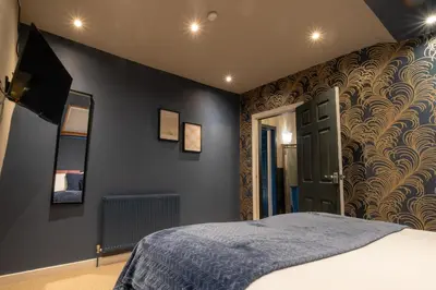 a bedroom with a bed and a blue wall at Entire Modern House Liverpool, 6 Bedrooms in Liverpool