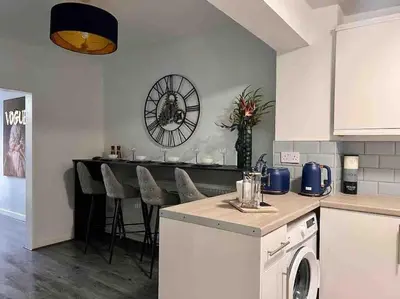 a kitchen with a table and a clock on the wall at 2 Bed Newly Furbished Whole House sleeps 4 in Liverpool