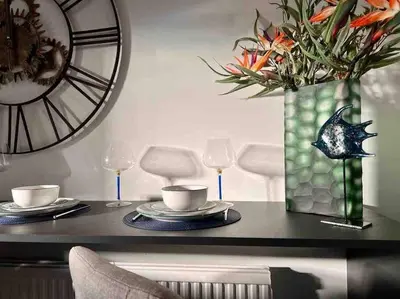 a dining table with a vase of flowers and glasses at 2 Bed Newly Furbished Whole House sleeps 4 in Liverpool