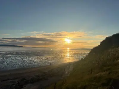 a beach with the sun rising over the water at 2 Bed Newly Furbished Whole House sleeps 4 in Liverpool