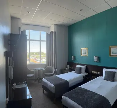 a hotel room with two beds and a table at Royal Clifton Hotel in Southport