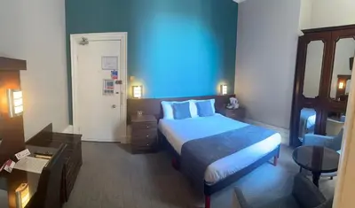 a hotel room with a bed and a blue at Royal Clifton Hotel in Southport