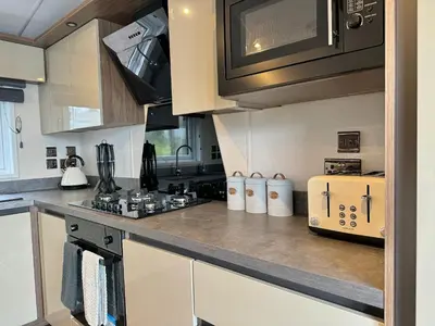 a kitchen with a stove and a microwave at Luxury Langham Lodge in Clitheroe