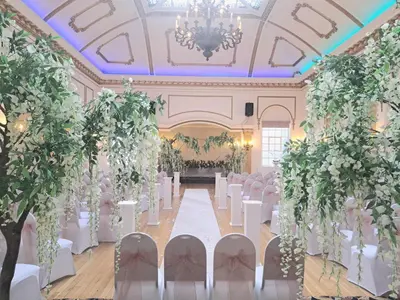 a banquet hall with white chairs and a chandelier at Prince Of Wales Hotel in Southport