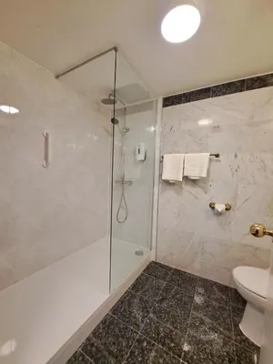 a bathroom with a shower and a toilet at Prince Of Wales Hotel in Southport
