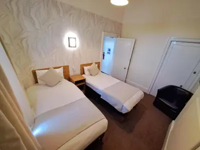a hotel room with two beds and a small room at Prince Of Wales Hotel in Southport