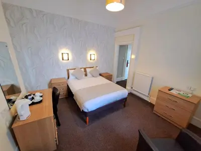 a hotel room with a bed and a desk at Prince Of Wales Hotel in Southport