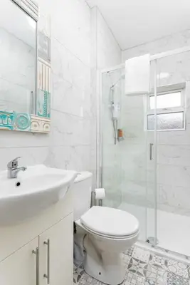 a white bathroom with a toilet and a sink at Flatzy - Modern 3 Bedroom Home in City Centre in Liverpool