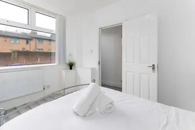 a white bedroom with a white bed and a window at Flatzy - Modern 3 Bedroom Home in City Centre in Liverpool