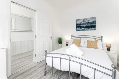 a white bedroom with a bed and a window at Flatzy - Modern 3 Bedroom Home in City Centre in Liverpool