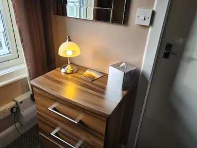 a desk with a lamp on it in a room at The Penkelie in Southport