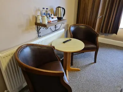a room with two chairs and a table and a table and chairs at The Penkelie in Southport