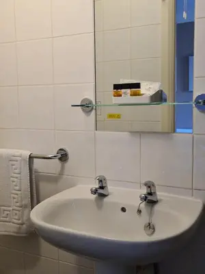 a white sink in a bathroom with a mirror at The Penkelie in Southport
