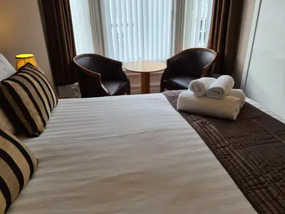 a hotel room with a bed with two towels on it at The Penkelie in Southport