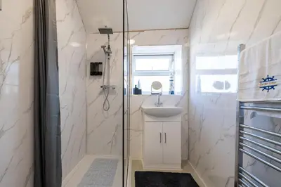 a bathroom with a shower and a sink at The Bay Cottage Hot Tub & Sauna Morecambe Bay in Morecambe