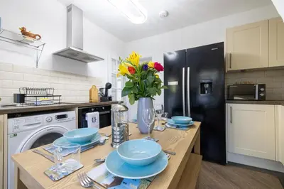 a kitchen with a table with bowls and flowers on it at The Bay Cottage Hot Tub & Sauna Morecambe Bay in Morecambe
