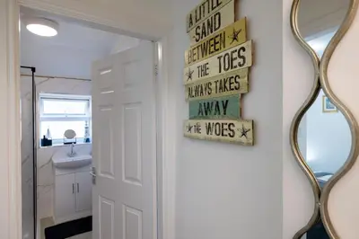 a bathroom with a white door and a mirror at The Bay Cottage Hot Tub & Sauna Morecambe Bay in Morecambe