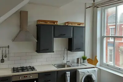 a kitchen with a sink and a washing machine at Large 2 Bedroom City Centre Apartment + Parking in Preston