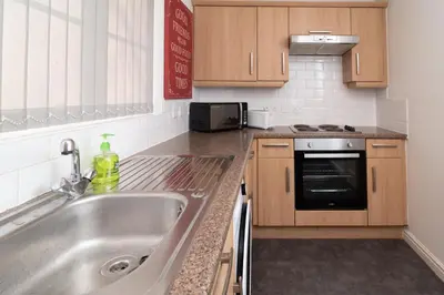 a kitchen with a sink and a stove at Central Liverpool Haven 3 bedroom House Private Parking in Liverpool