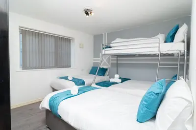 two bunk beds in a room with blue and white at Central Liverpool Haven 3 bedroom House Private Parking in Liverpool