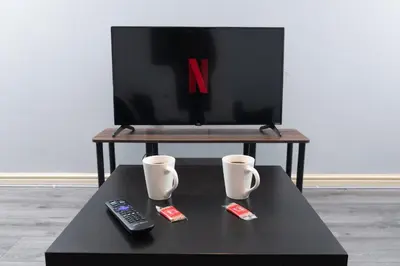 a coffee table with two remote controls and a tv at Central Liverpool Haven 3 bedroom House Private Parking in Liverpool