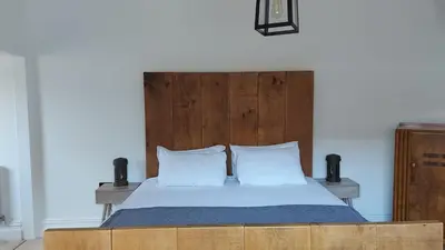 a bed with a wooden headboard and two white pillows at Superking Size City Centre En-Suite Room + Parking in Preston