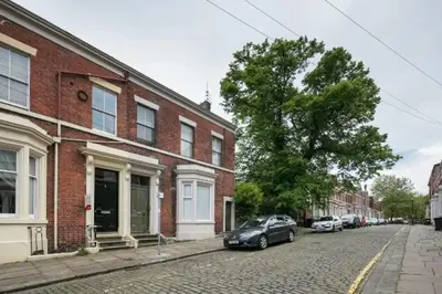 a car parked on a street next to a brick building at Stylish Double Room in City Centre - Shared Bathroom - Parking in Preston