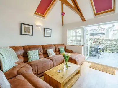 a living room with a brown couch and a table at 3 Bed in Grange-over-sands oc-83368 in Cartmel