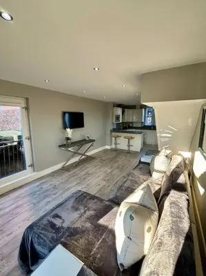 a living room with a couch and a tv at Entire Town House In Liverpool Marina in Liverpool