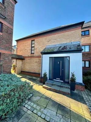 a brick building with a blue door on it at Entire Town House In Liverpool Marina in Liverpool
