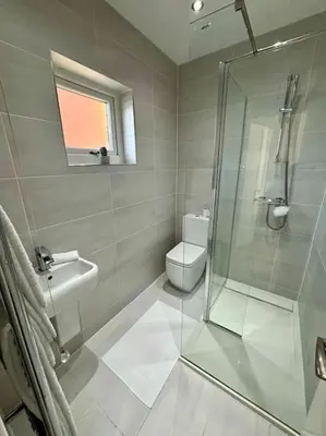 a bathroom with a glass shower and a toilet at Entire Town House In Liverpool Marina in Liverpool